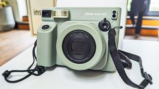 A Fujifilm Instax Wide 400 instant camera in the sage green colorway