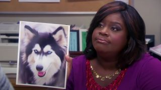 Retta as Donna Meagle, posing with a photo of a Husky