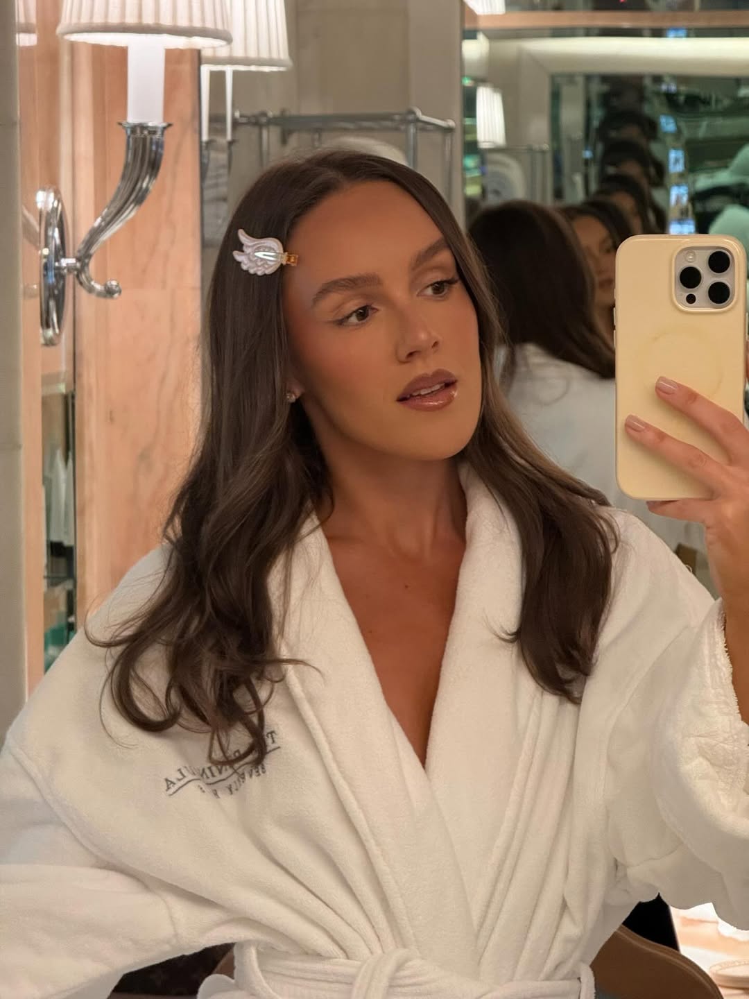 Emma Leger photographs herself in the reflection of a mirror wearing an Emi Jay claw clip in her wavy hair