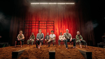 The cast of Sunset Song sit in a row on stage, with Danielle Jam at the front centre
