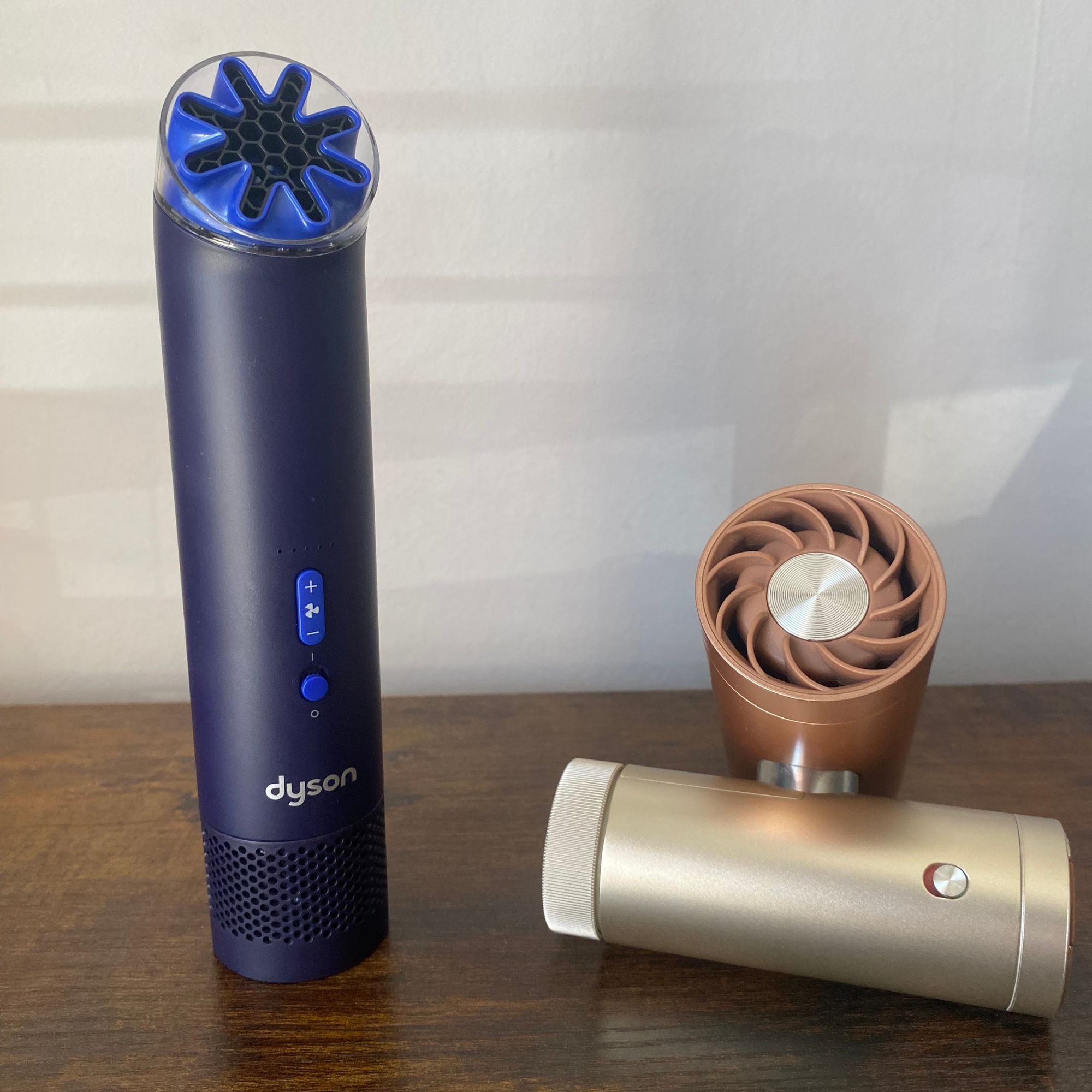 Dyson HushJet Mini Cool Fan on a wooden surface next to the Shark ChillPill intwisted configuration