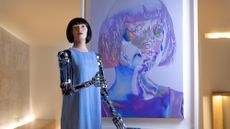 The robot artist "Ai-Da" stands in front of one of her self-portraits during the opening of her new exhibition at the Design Museum in London on May 18.