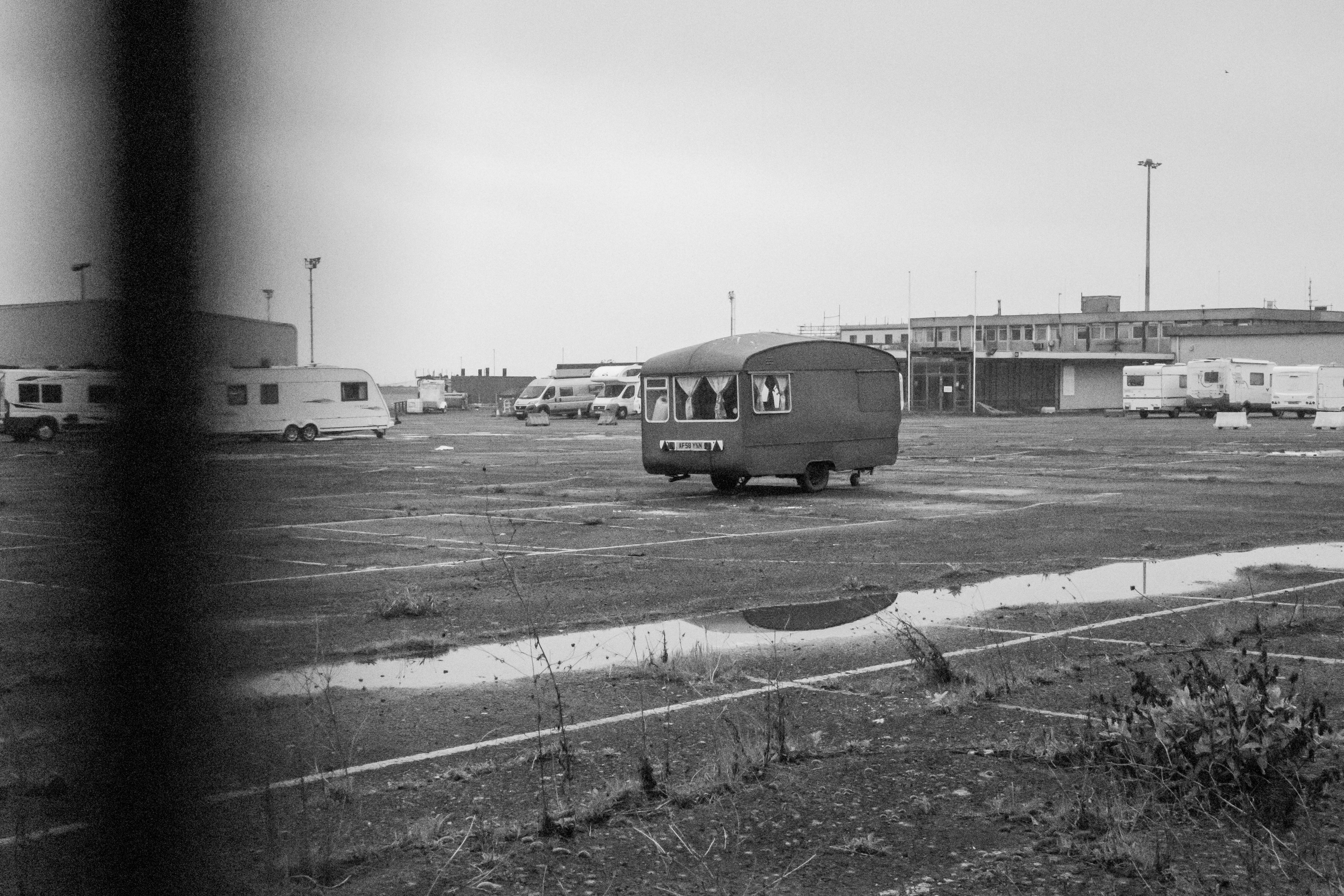 Canon PowerShot V1 black and white photo of a caravan in a car park