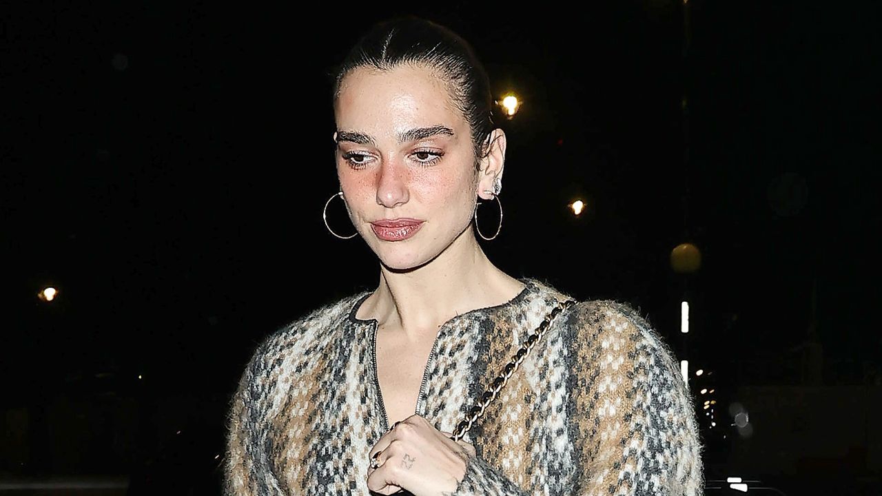 Dua Lipa leaving a London party in a statement sweater dress and furry trouser boots