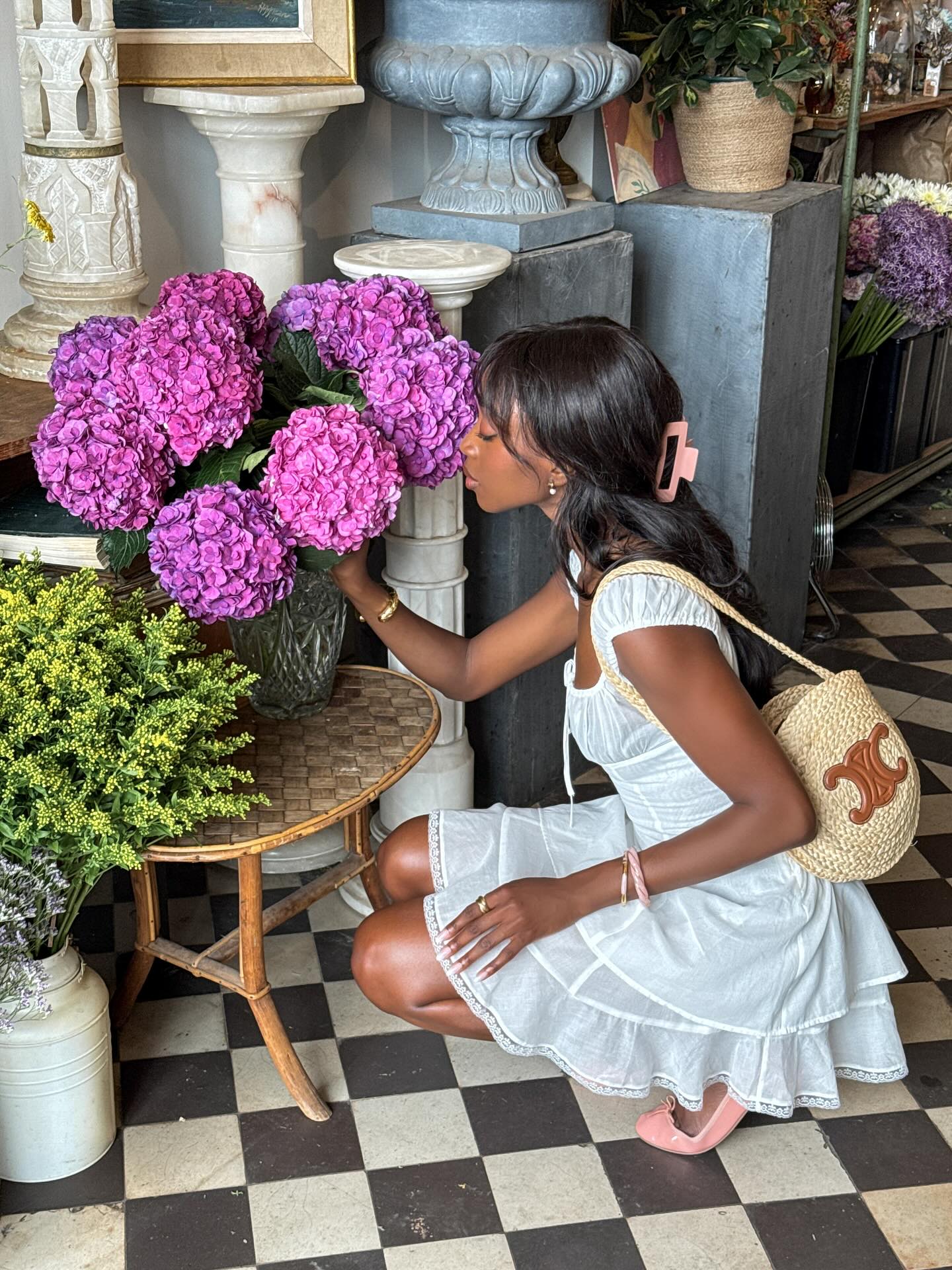 Emmanuelle wears a white cotton dress, ballet flats and a Celine Basket Bag