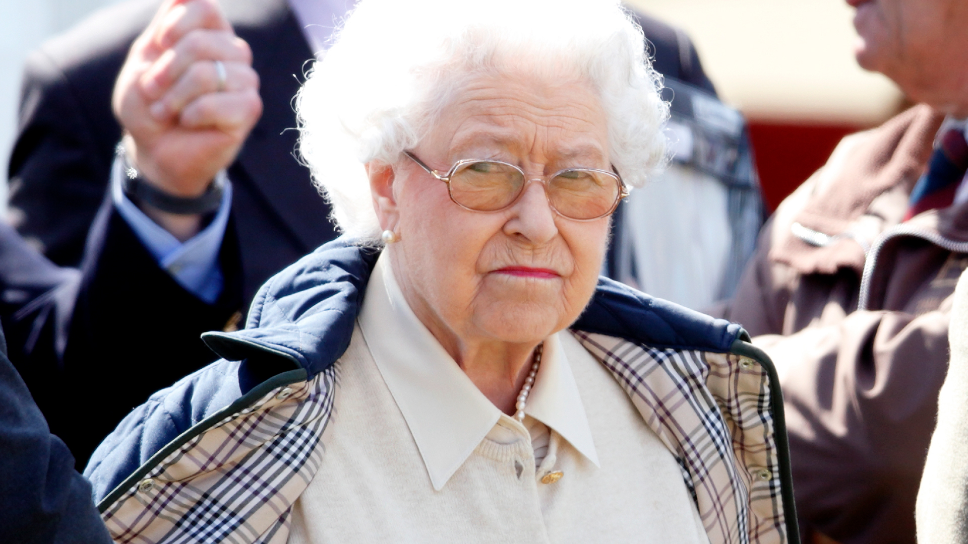 Queen Elizabeth II has pursed lips and white hair and looks very annoyed