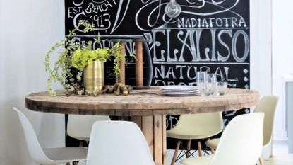 blackboard on wall with wooden dining table and chairs