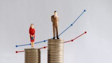 Man and woman standing on coins showing men get paid more 