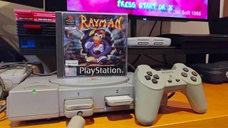 Rayman PS1 case sitting on top of console next to controller.