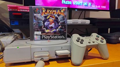 Rayman PS1 case sitting on top of console next to controller.