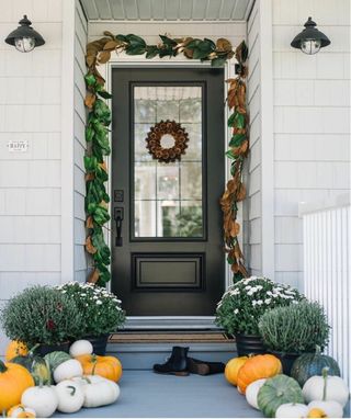 Fall porch with leaf garland, pumpkins, boots and wreath
