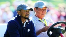 Tiger Woods sits in a golf cart alongside close friend Notah Begay III
