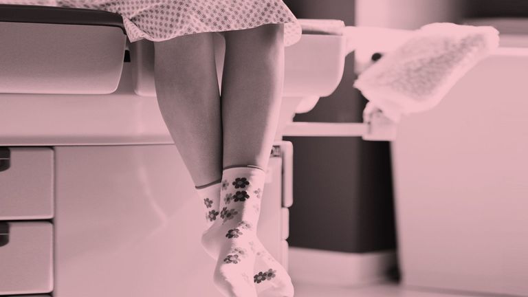 Persons legs hanging over edge of hospital bed wearing flower socks