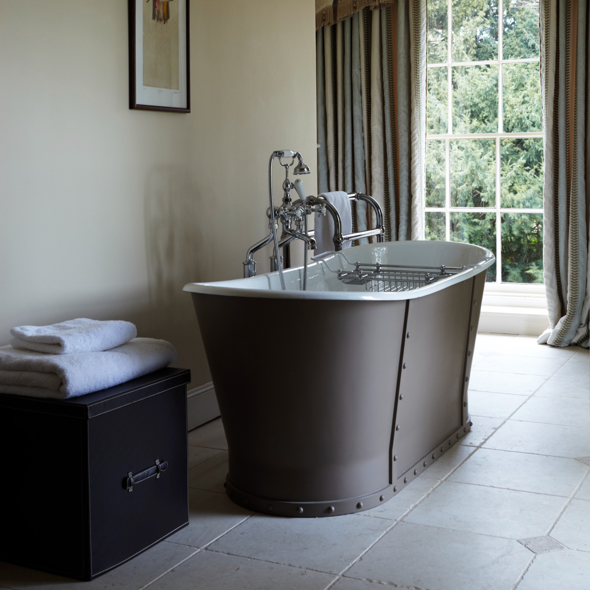 A large neutral bathroom with a freestanding bathtub painted in Farrow &amp;amp; Ball's brown Dauphin shade