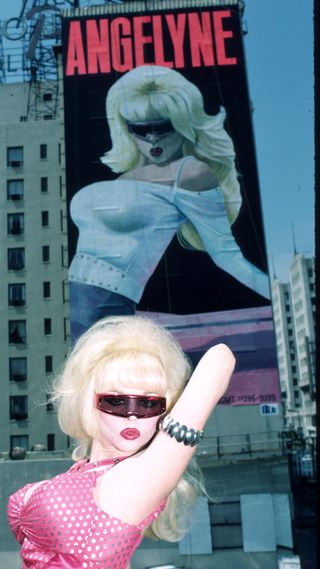 Singer Angelyne poses in front of her billboard July 1987 in Los Angeles, CA. Angelyne will release her new album"Beware of My Boyfriend" this month and is famous for her posters.