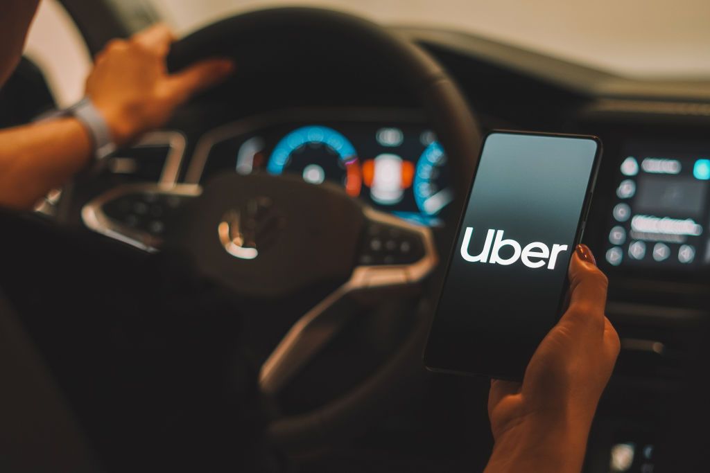 car driver looking at Uber app on smartphone