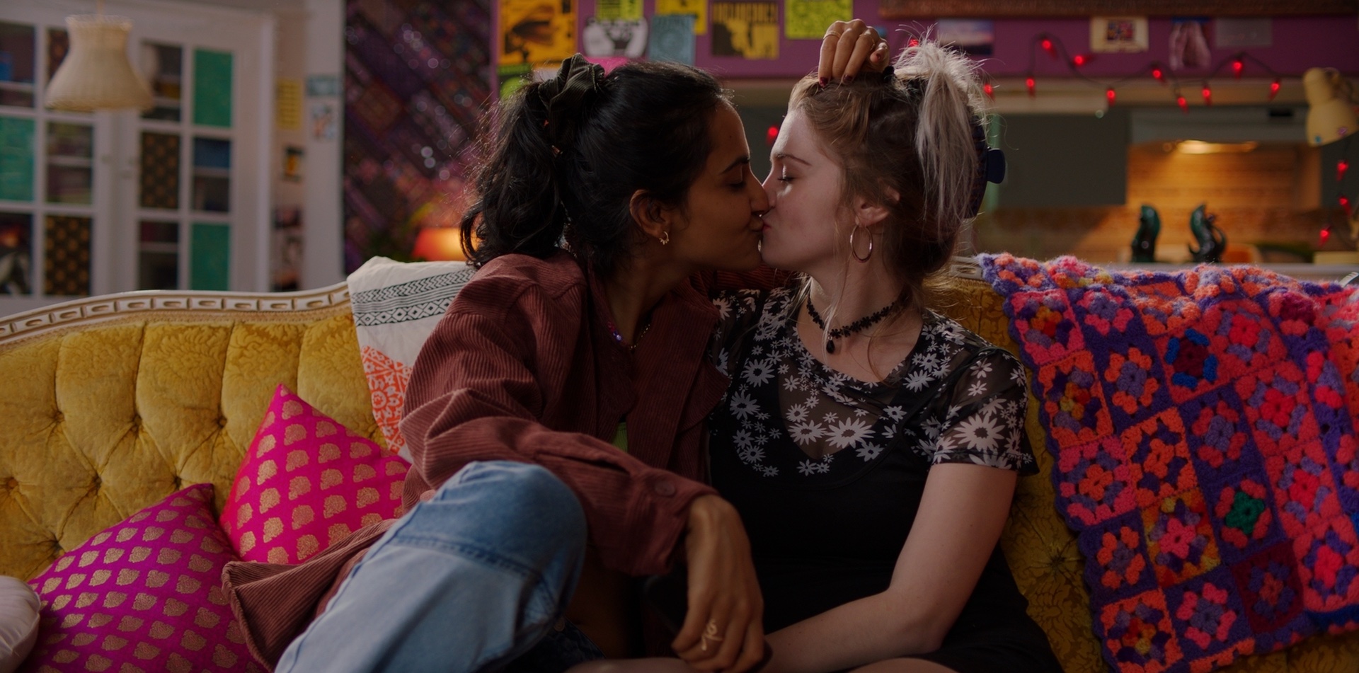 Amrit Kaur as AzraKaya Mosley as Rachel kisisng on a couch in the movie queen of my dreams