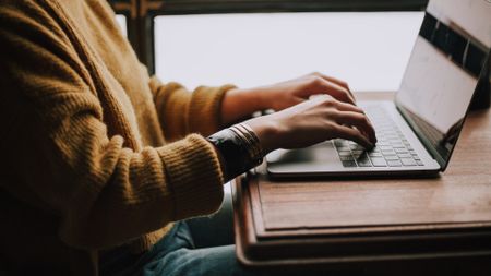 Person typing on laptop keyboard