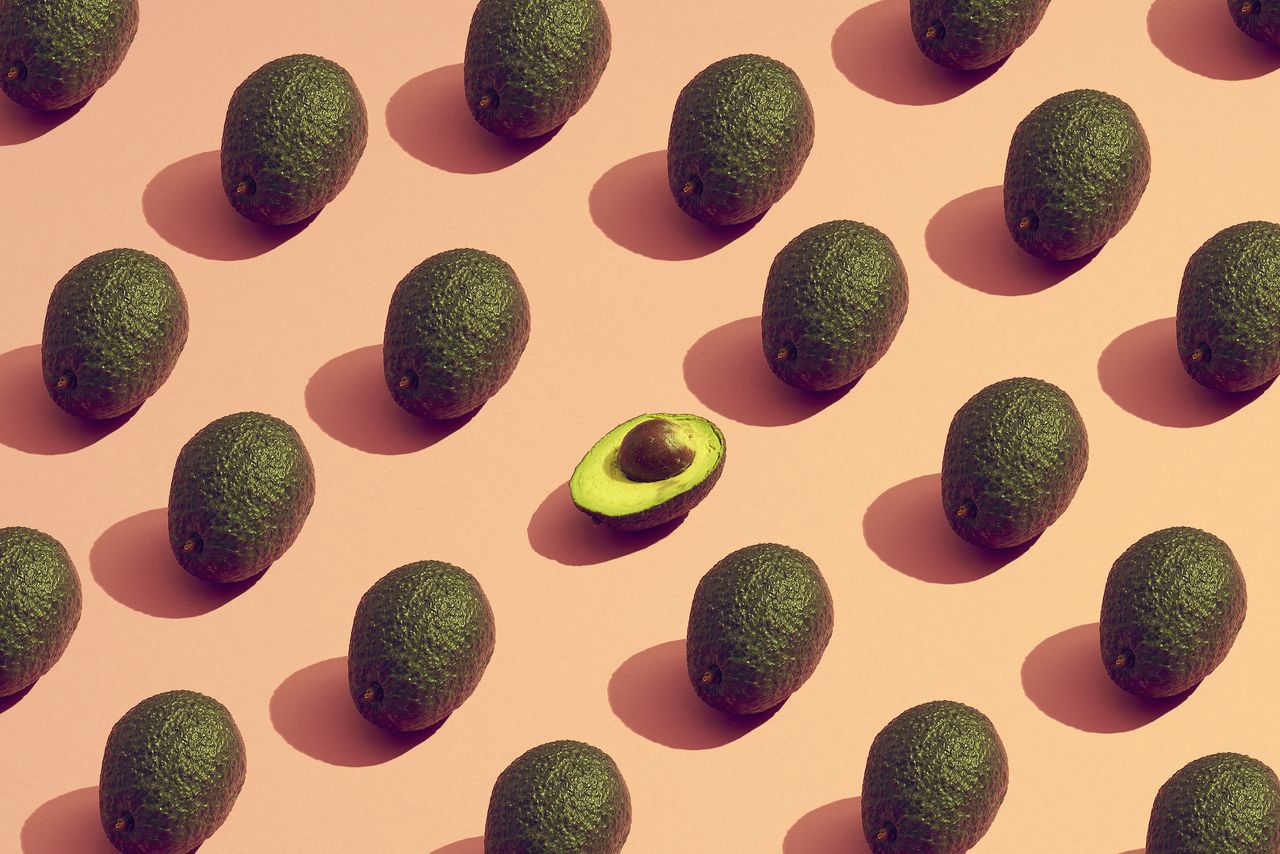 Th benefits of avocado shown in a pattern made from avocados.