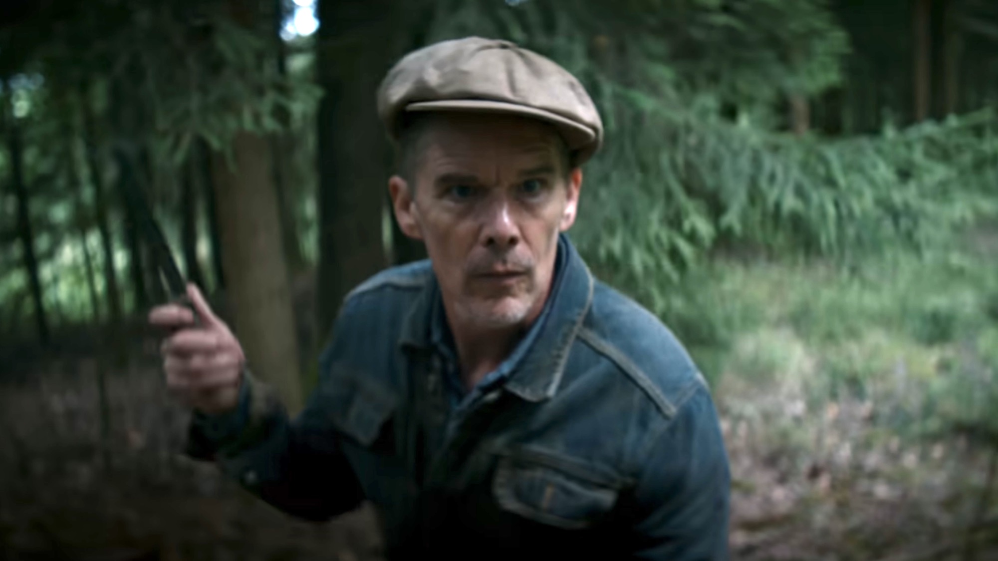 Ethan Hawke holding a knife in The Weight. 
