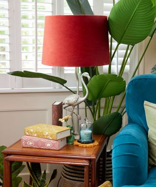 Fearne Cotton's wooden side table with two blue tapered candles and flamingo lamp with pink shade