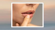 A close up shot of a woman's mouth, with her finger touching her bottom lip on a graduated backdrop