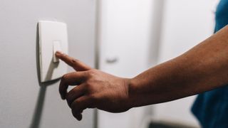 picture of woman turning light switch off