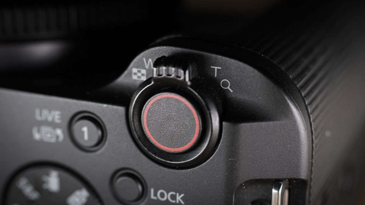 Canon EOS R50 V on a wooden surface, against a dark background