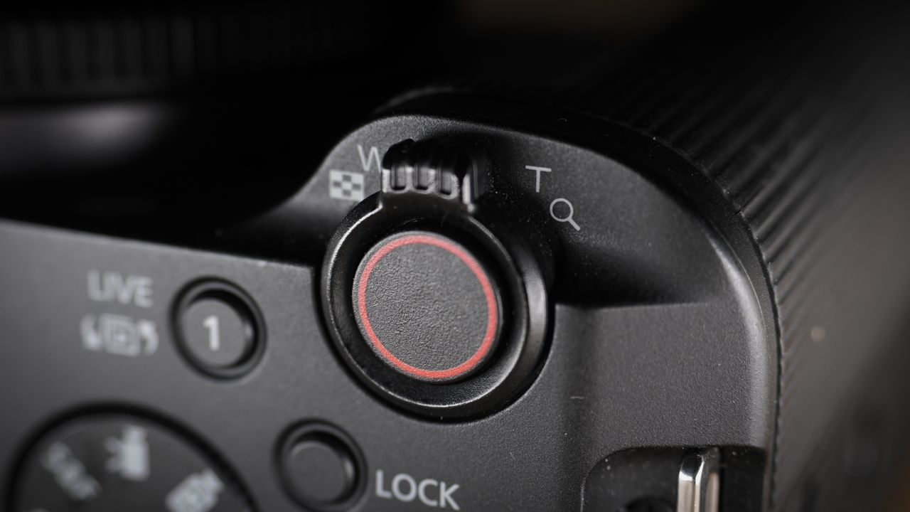 Canon EOS R50 V on a wooden surface, against a dark background