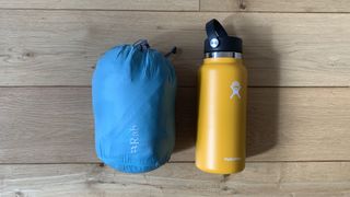 Rab Infinity Microlight jacket in its stuff sack with water bottle for scale