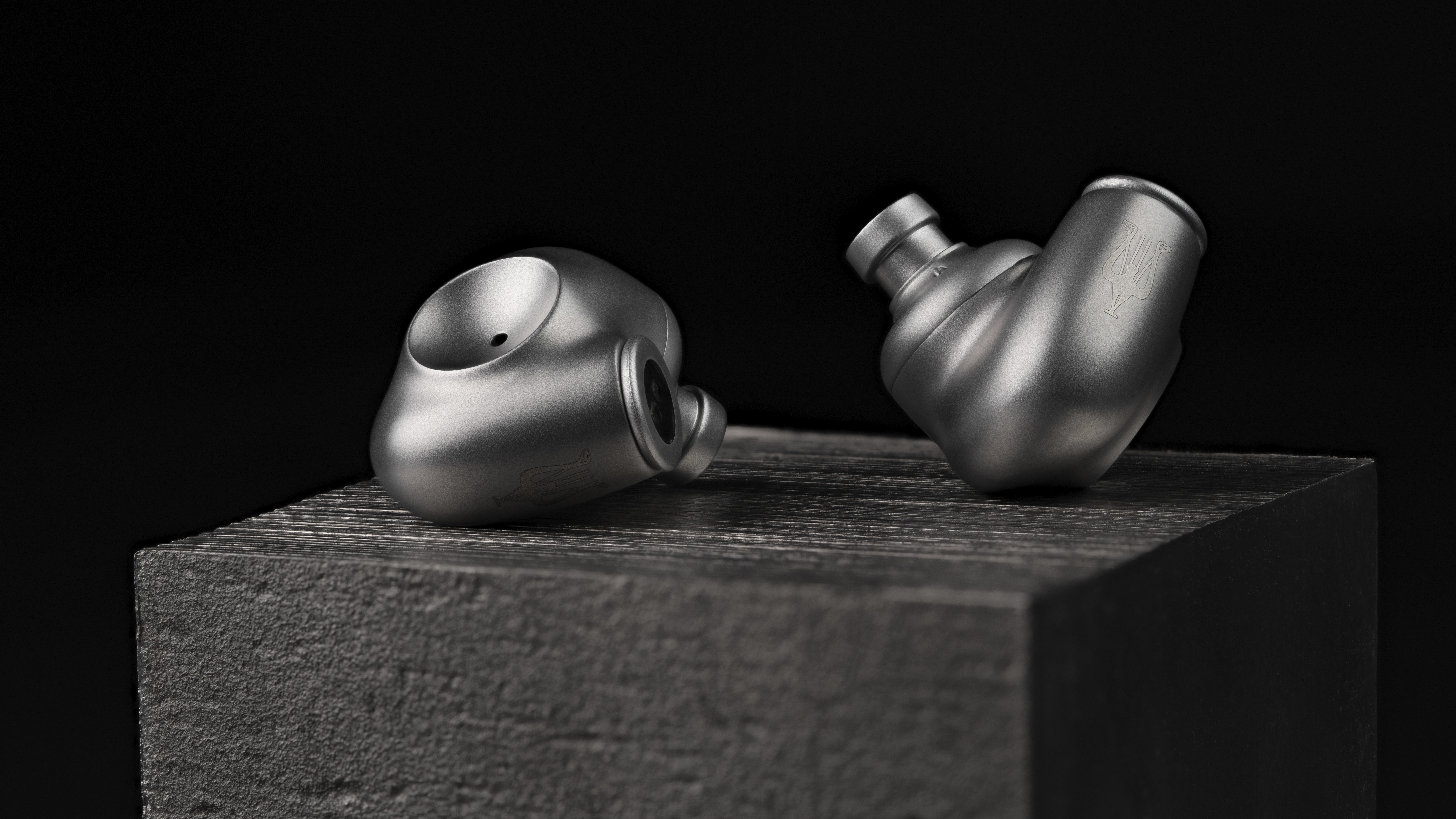 Meze Astru wired in-ear headphones in silver on a metallic plinth