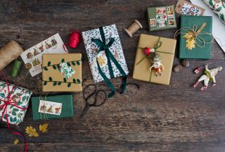 brown paper christmas wrapping on presents on a wooden floor