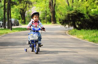 Child learning how to ride a bike.