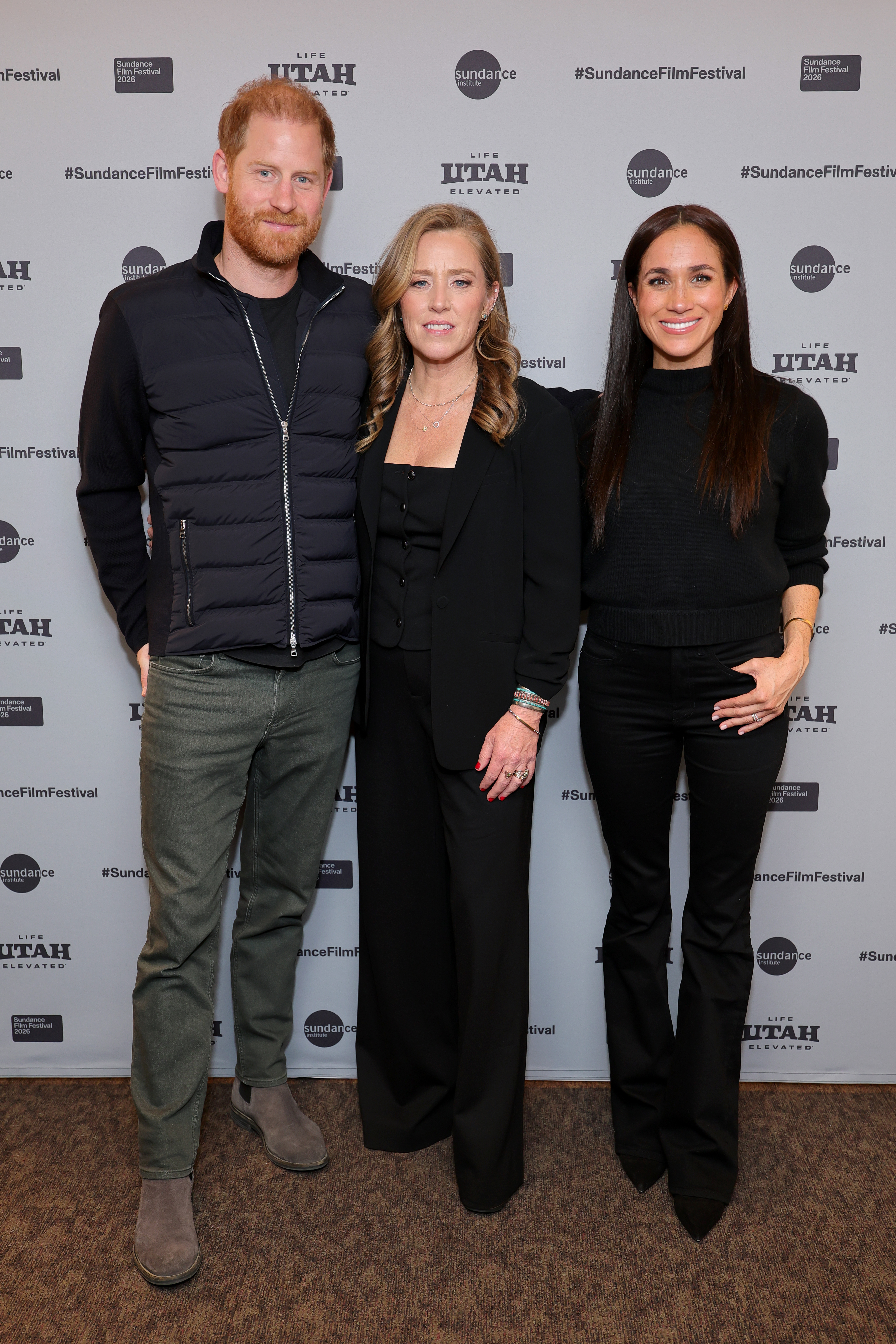 Meghan Markle poses wearing Mother black bootcut jeans and black sweater, and a brown cashmere coat, at the Salt Lake City celebration and premiere of "Cookie Queens" at Sundance Film Festival on January 24, 2026 in Salt Lake City, Utah