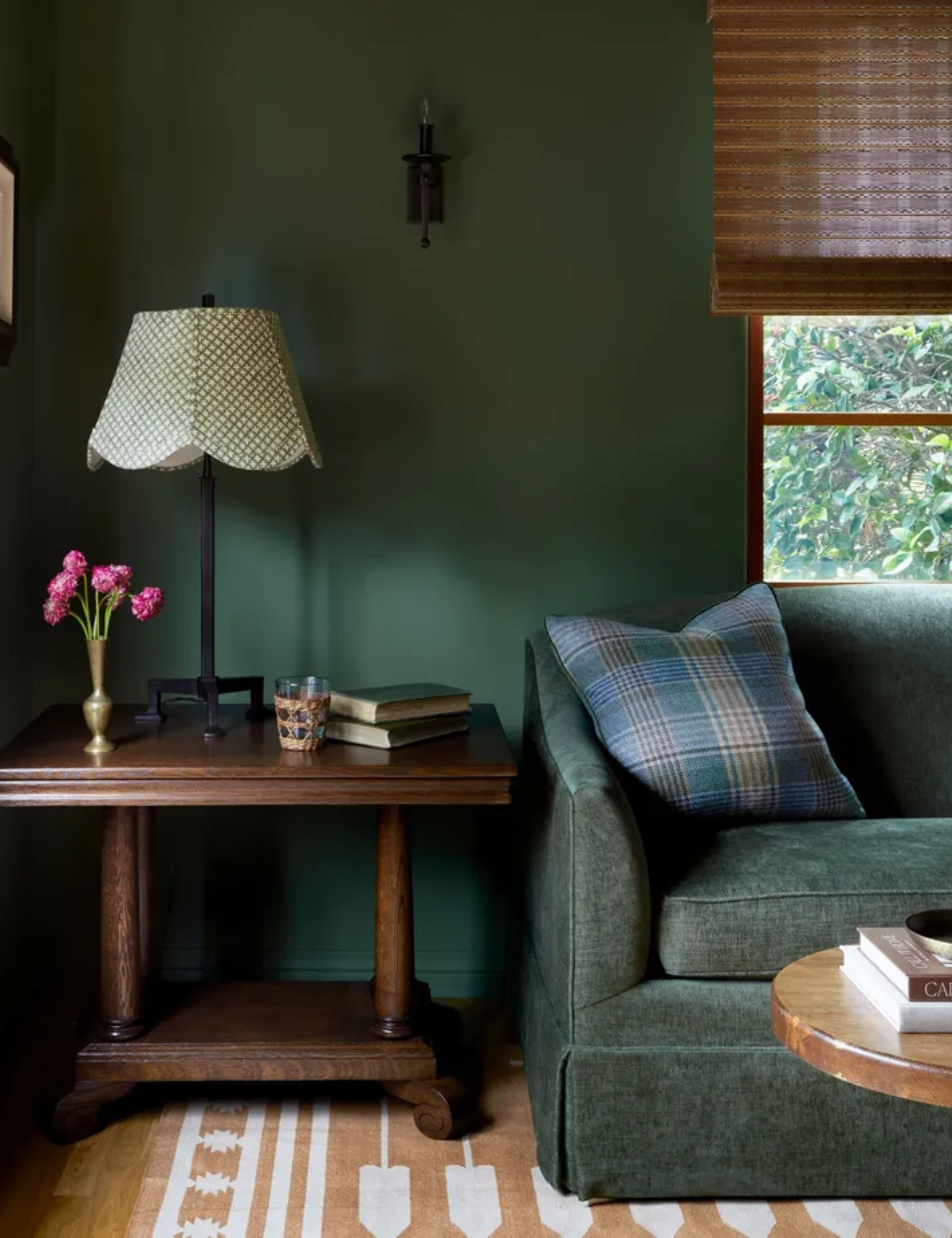 Dark green living room with dark green sofa ad white and jute rug