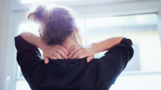 Woman feeling stressed with a sore scalp looking out of the window