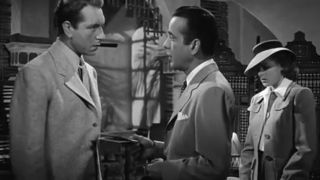 Humphrey Bogart pushing papers into Paul Henreid stomach in Casablanca