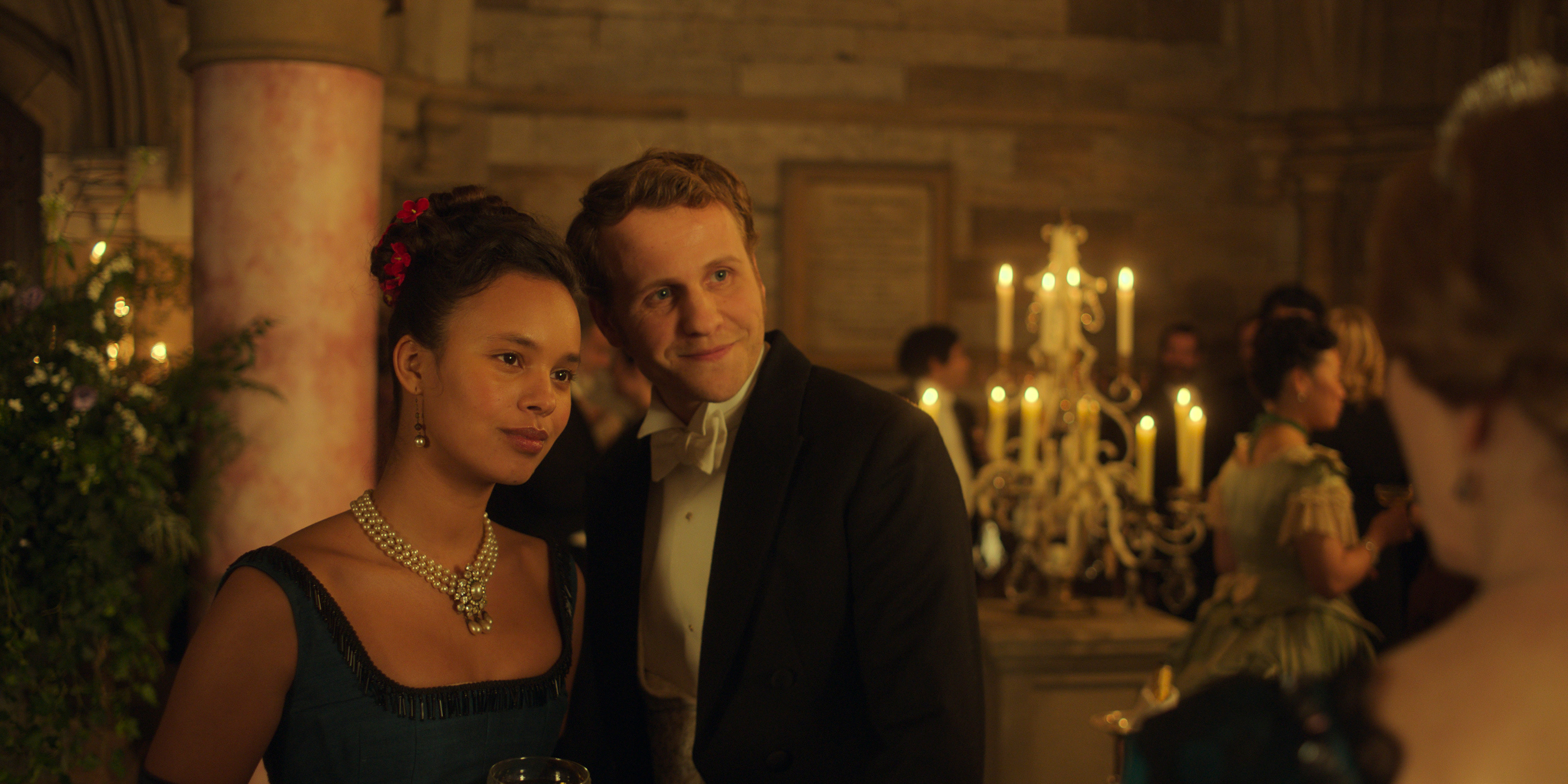alisha boe and josh dylan at a dimly lit ball in season 1 of the buccaneers