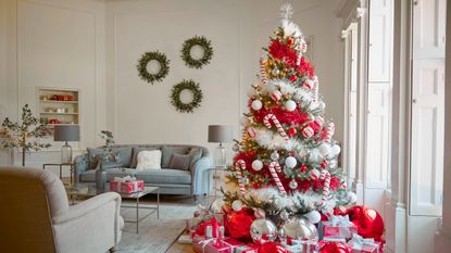 A bow-decorated Christmas tree next to a fireplace