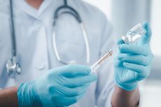 A healthcare professional holding a vaccine.