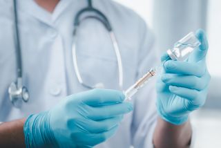 A healthcare professional holding a vaccine.