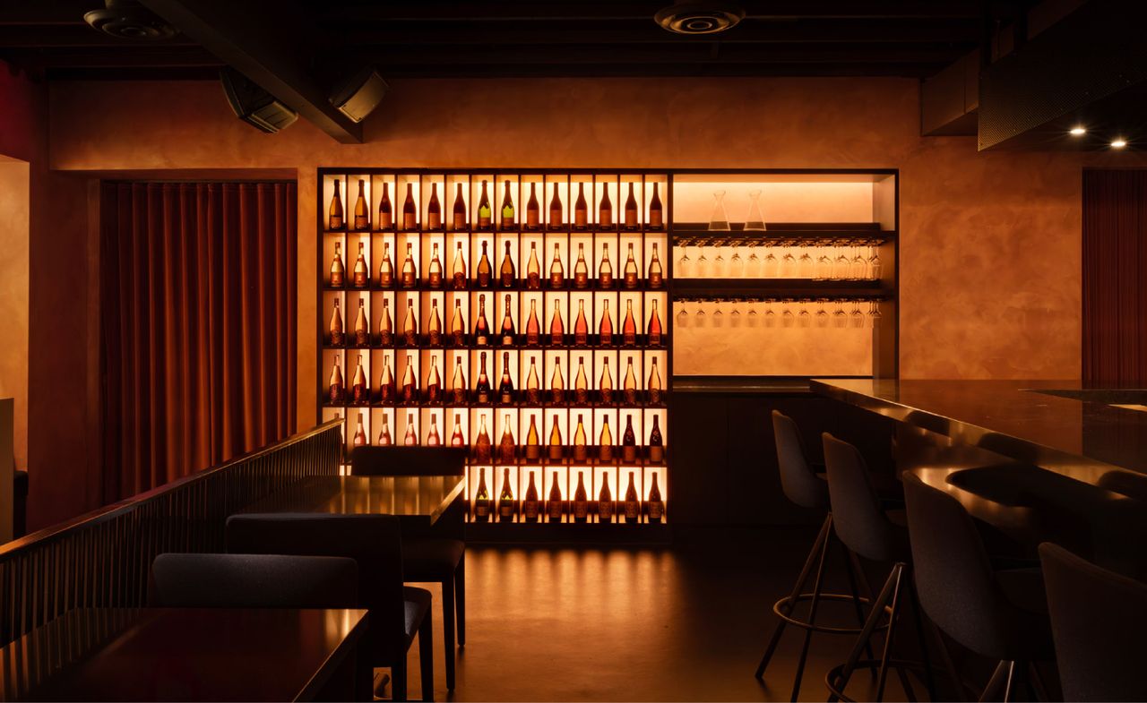 Wine exhibit at Ama Bar, illuminate by an orange glow