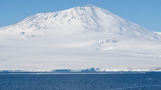 An ocean view of a snow-covered volcano in Antarctica