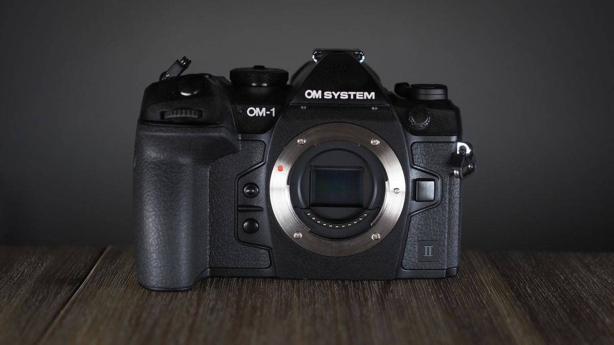 OM System OM-1 Mark II on a wooden surface, against a dark background