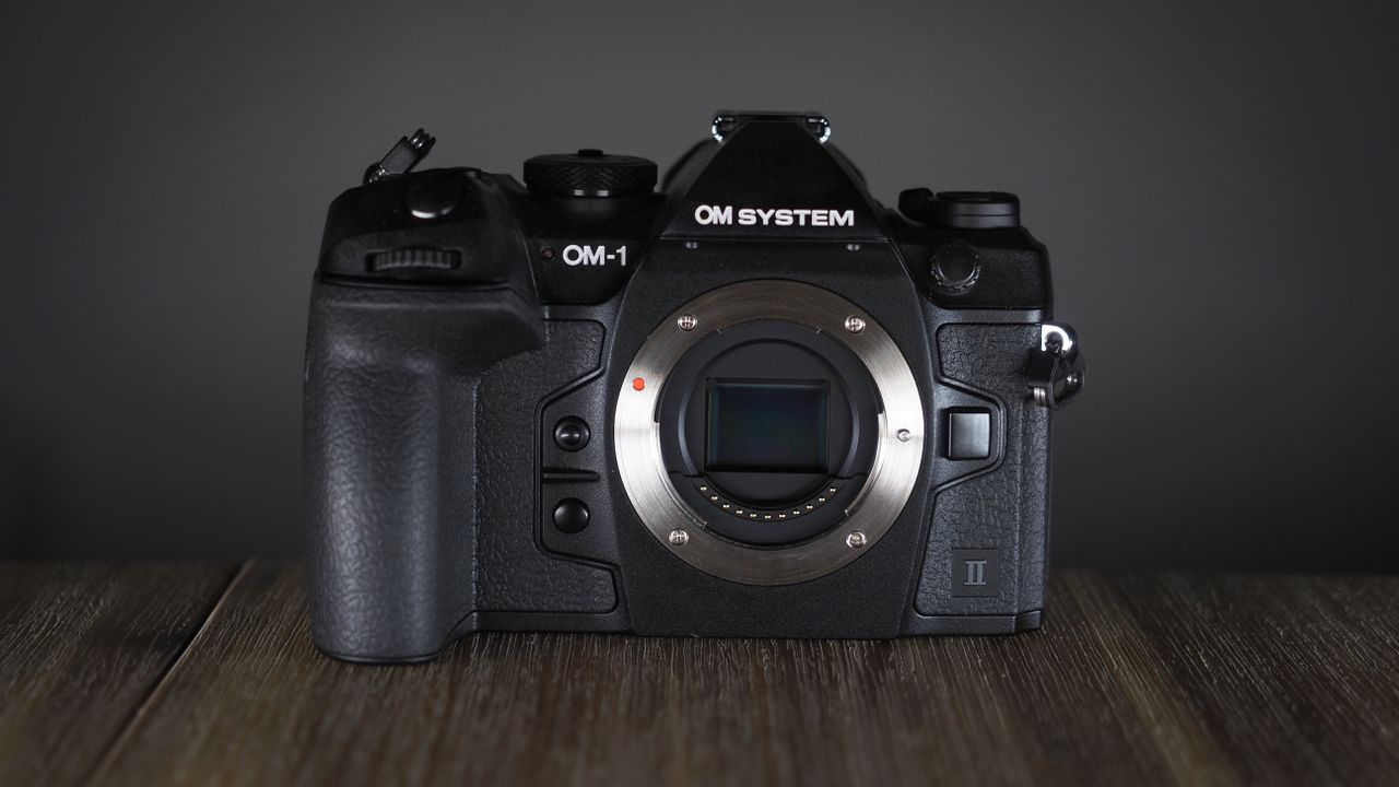 OM System OM-1 Mark II on a wooden surface, against a dark background