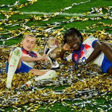 Chloe Kelly and Michelle Agyemang of England celebrate with the UEFA Women's EURO trophy while laying in ticker tape after their team's victory in the UEFA Women's EURO 2025 Final match between England and Spain at St. Jakob-Park on July 27, 2025 in Basel, Switzerland.