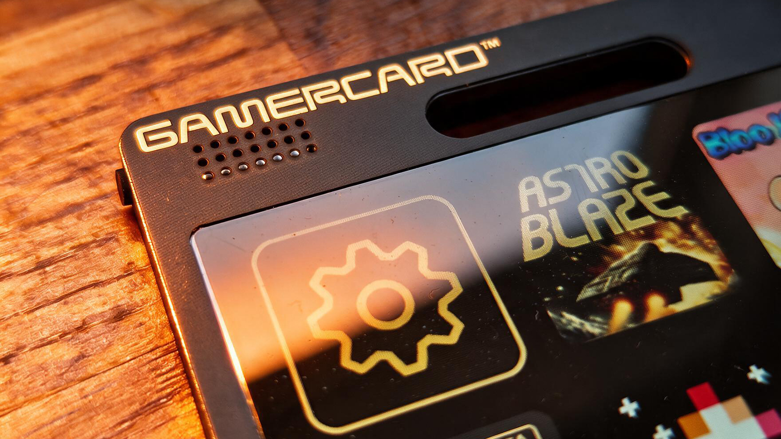 A small black gaming handheld in a wooden table