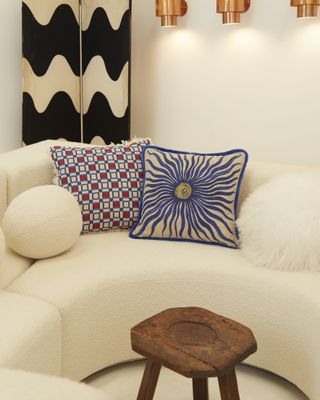 A white sofa with Greek inspired cushions with blue and white patterns