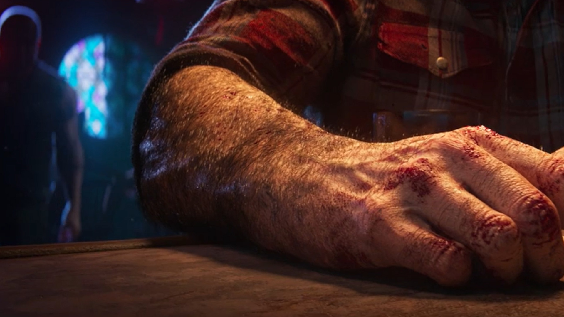 A screenshot of a close-up of Logan's bloody knuckles resting on a bar with an enemy slowing approaching him.