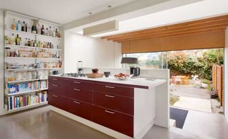 red and white open plan kitchen with view of garden